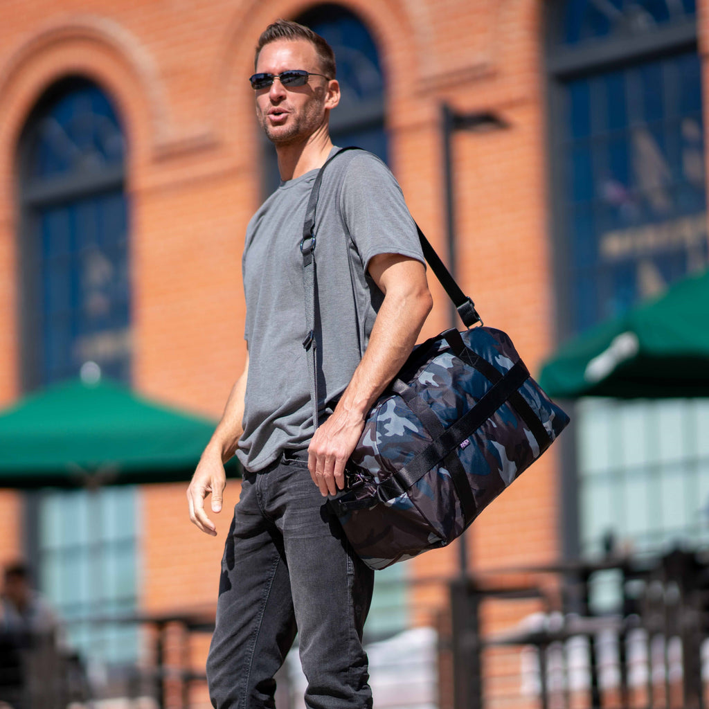 Man carrying convertible ANDI duffel bag on his shoulder | removable and adjustable strap | Nylon Travel bag
