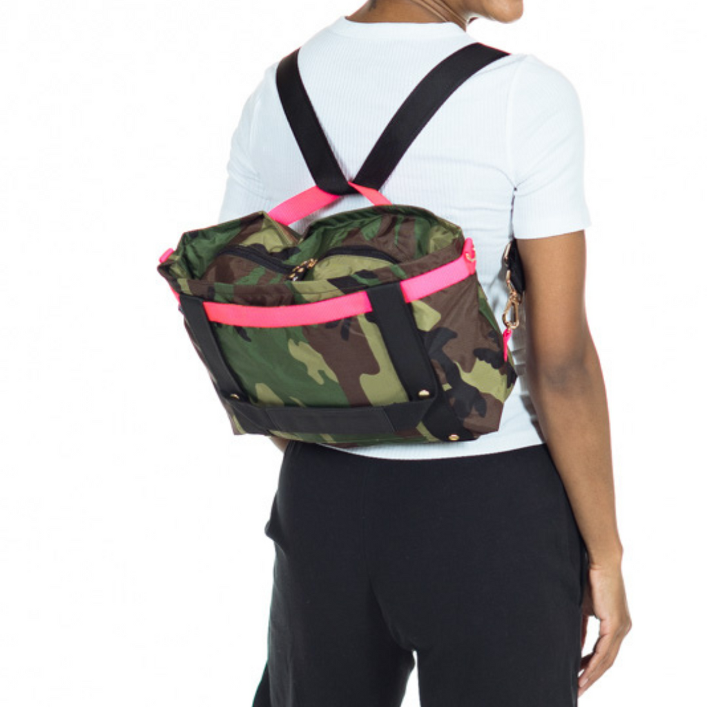 ANDI Small convertible cross-body tote on a model | Camouflage with hot pink trim