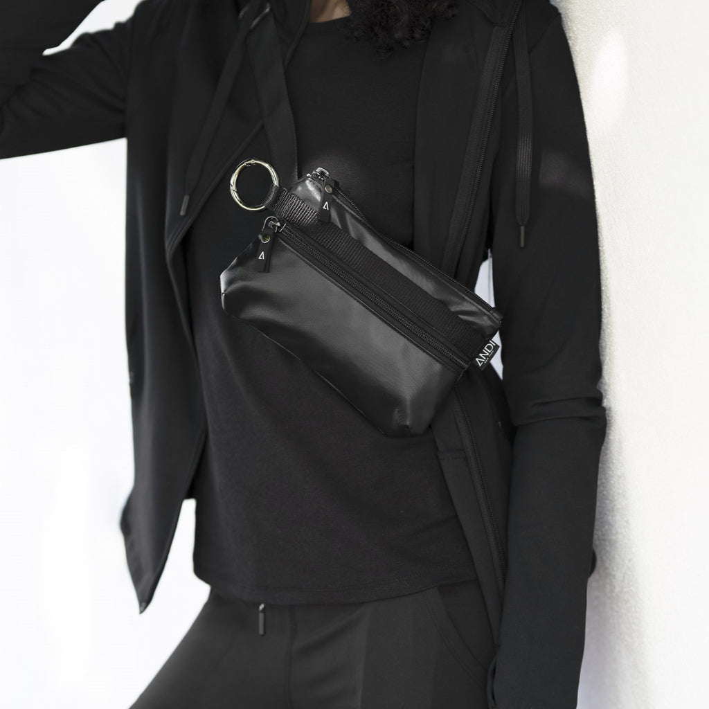 Woman wearing ANDI convertible belt bag across her chest | Back Onyx