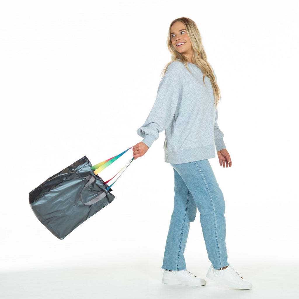 Woman carrying reusable ANDI shopping bag in metallic silver color | Machine-washable nylon
